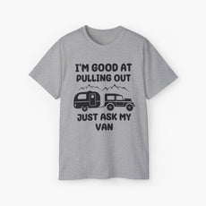 Grey t-shirt with humorous text 'I'm good at pulling out, just ask my van,' featuring an image of a truck pulling a camping van, set against mountains on a plain background.