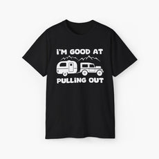 Black t-shirt with humorous text 'I'm good at pulling out' featuring an image of a truck pulling a camping van, set against mountains on a plain background.