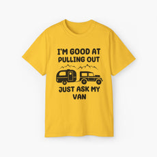 Yellow t-shirt with humorous text 'I'm good at pulling out, just ask my van,' featuring an image of a truck pulling a camping van, set against mountains on a plain background.