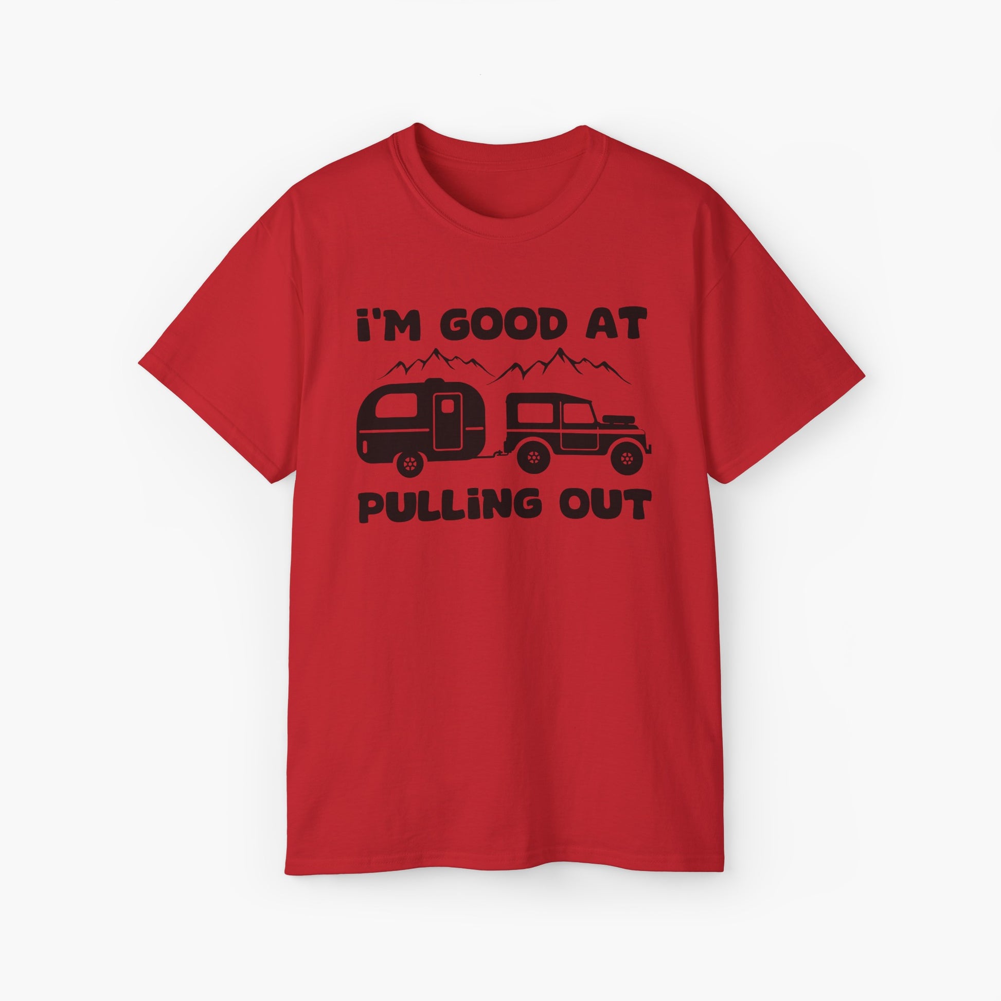 Red t-shirt with humorous text 'I'm good at pulling out' featuring an image of a truck pulling a camping van, set against mountains on a plain background.