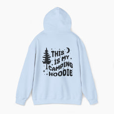 Back of light blue hoodie featuring the text 'This is my camping hoodie,' with a design of a camping van, moon, stars, and a tree on a plain background.