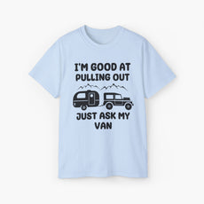 Light blue t-shirt with humorous text 'I'm good at pulling out, just ask my van,' featuring an image of a truck pulling a camping van, set against mountains on a plain background.