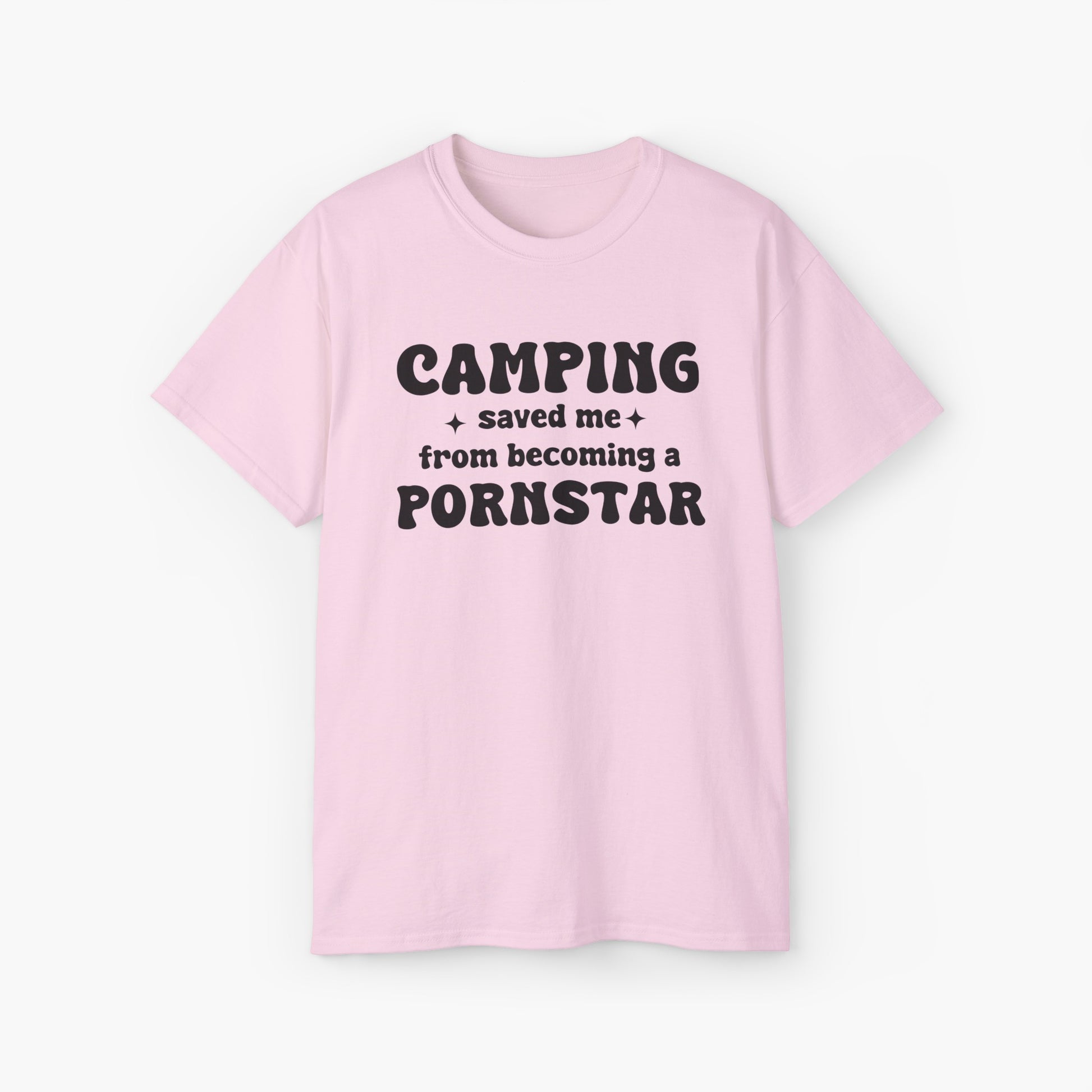 Light pink t-shirt with the bold statement 'Camping saved me from becoming a pornstar,' embellished with stars on a plain background.
