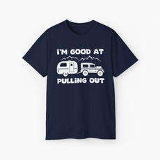 Dark blue t-shirt with humorous text 'I'm good at pulling out' featuring an image of a truck pulling a camping van, set against mountains on a plain background.