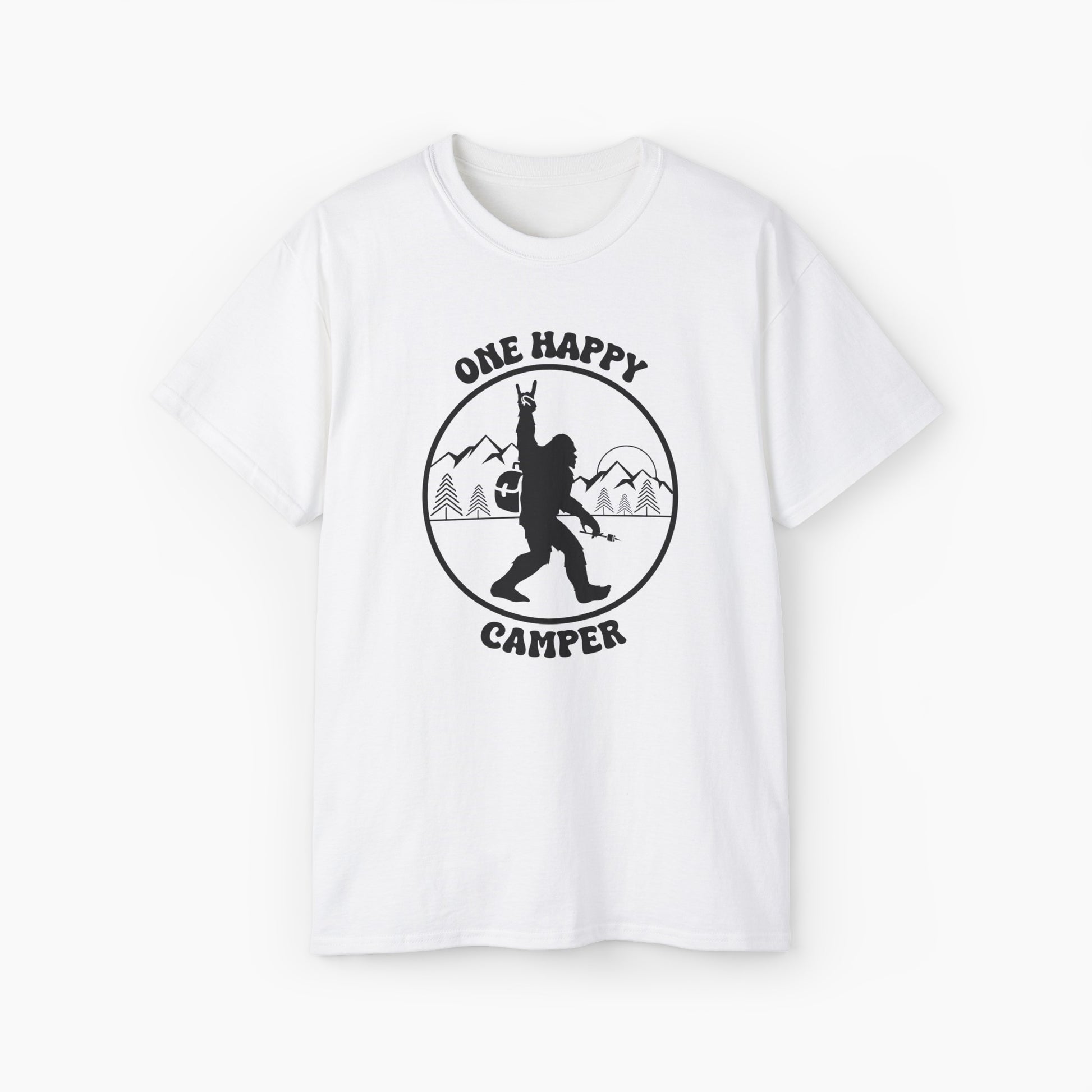 White t-shirt with 'One Happy Camper' text, featuring Bigfoot making a peace sign, set against a subtle background of trees and mountains.