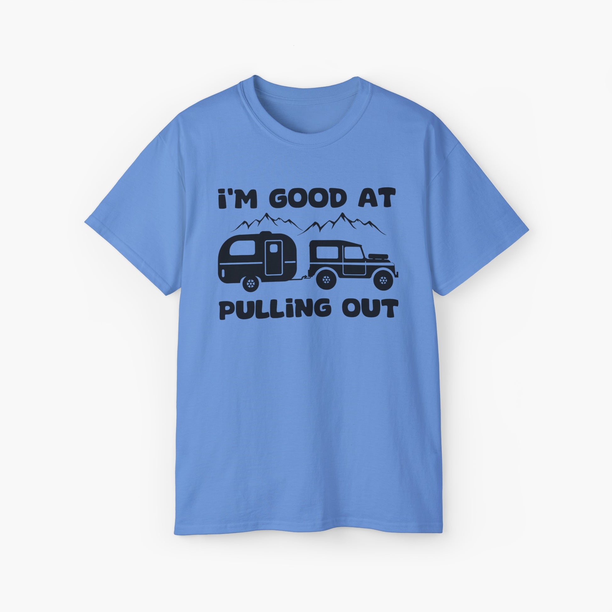 Blue t-shirt with humorous text 'I'm good at pulling out' featuring an image of a truck pulling a camping van, set against mountains on a plain background.