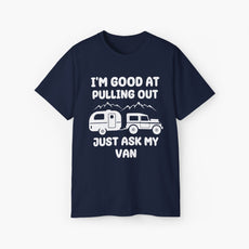 DArk blue t-shirt with humorous text 'I'm good at pulling out, just ask my van,' featuring an image of a truck pulling a camping van, set against mountains on a plain background.
