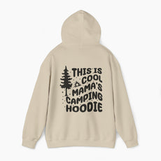 Sand color hoodie with the text 'This is cool mama's camping hoodie' on the back, featuring a tree and stars design on a plain background.