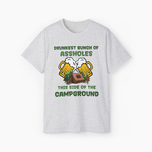 Light grey t-shirt with green text reading 'Drunkest bunch of assholes, this side of the campground,' featuring two glass of a beer, tent, and trees on a plain background.